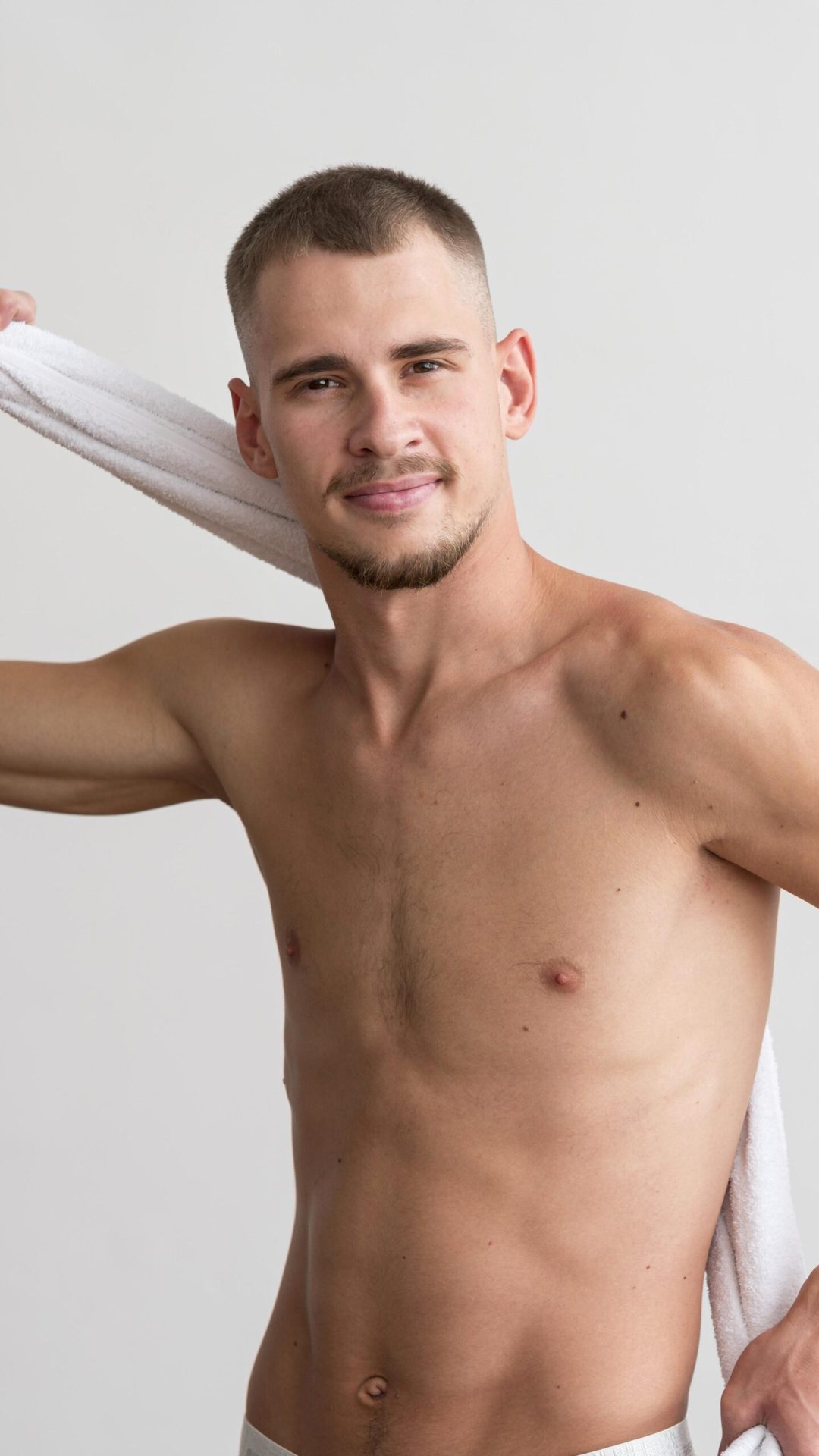 vista-frontal-de-um-homem-bonito-sem-camisa-posando-com-uma-toalha vista-frontal-de-um-homem-bonito-sem-camisa-posando-com-uma-toalha